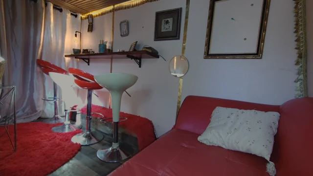 Curved red sofa, retro stools, and a wall of vintage details.