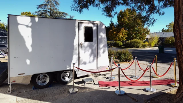 The actual white trailer and red-carpet setup, photographed from the side.